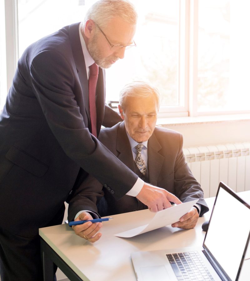 two-mature-businessman-discussing-business-project-office (1)